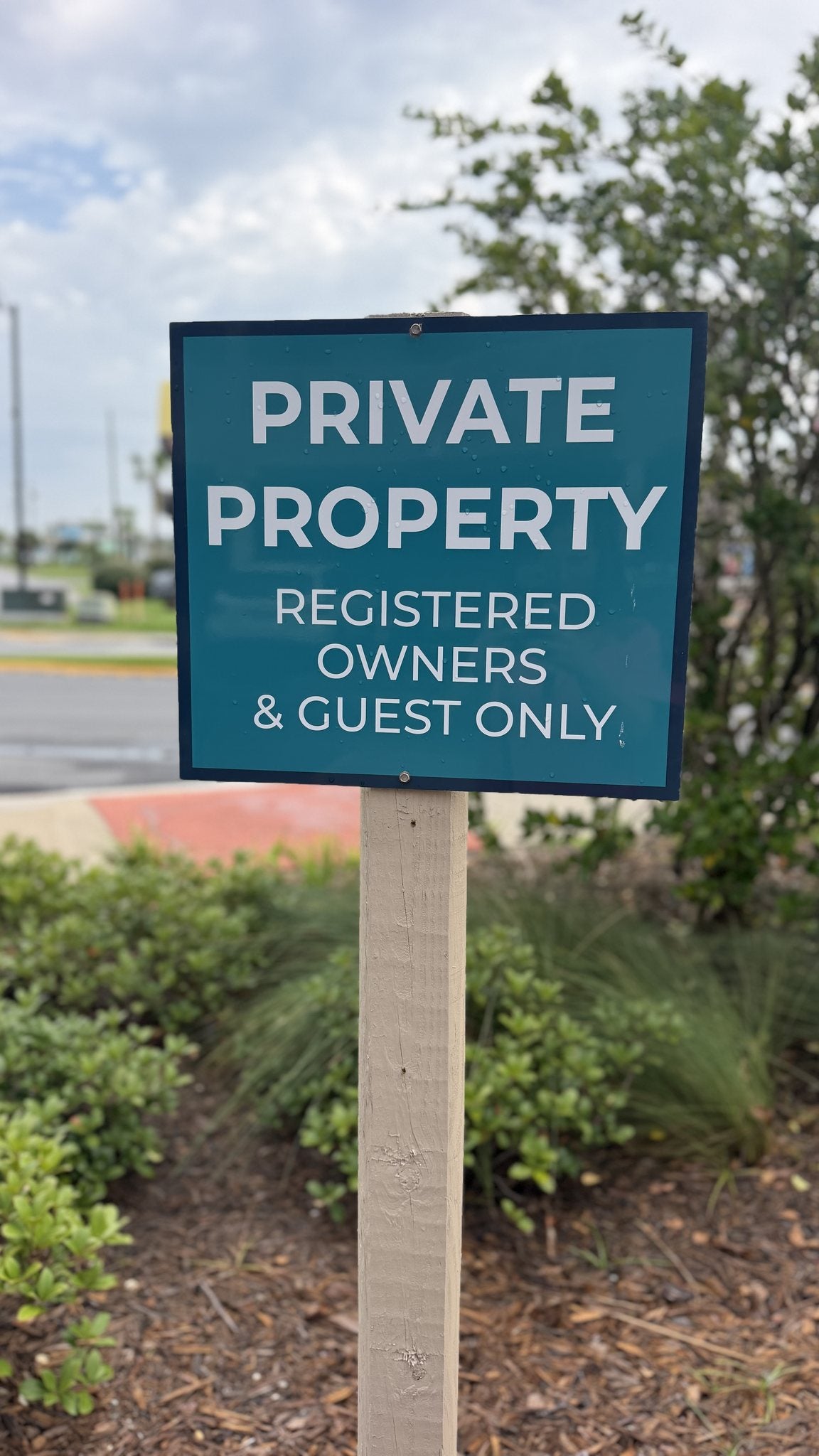 Private Property, registered owners and guests only ACM sign mounted on a post